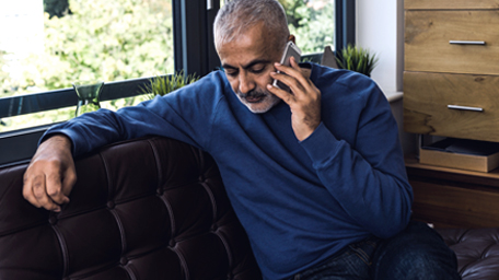 A man talks on a mobile phone in his home